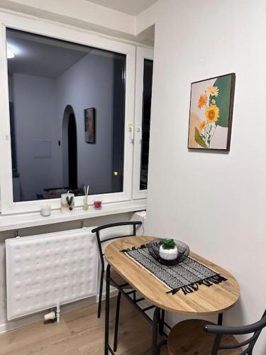 a table and chairs in a room with a window at 1 Izbovy Apartman - Širšie Centrum in Martin