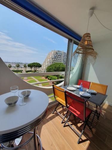 une salle à manger avec une table et des chaises et une grande fenêtre dans l'établissement T2 FIDJI vue Port et Mer Parking CLIM Wifi - ROSSIconciergerie - Linge en option, à La Grande Motte