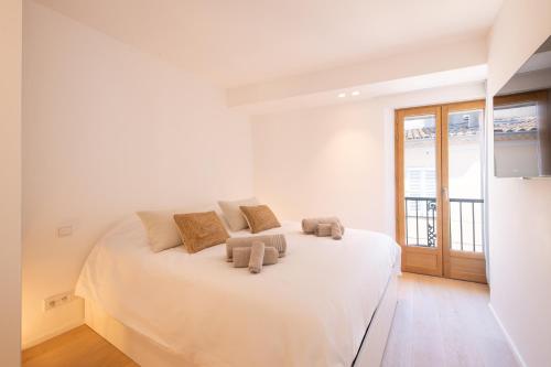 - une chambre blanche avec un grand lit blanc et 2 oreillers dans l'établissement ACQUA MARINA, appartement vue sur le port, à Saint-Tropez