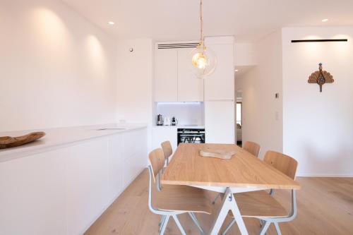 une cuisine et une salle à manger avec une table et des chaises en bois dans l'établissement ACQUA MARINA, appartement vue sur le port, à Saint-Tropez