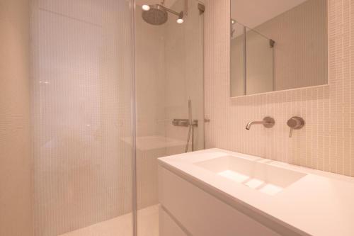 une salle de bain avec un lavabo et une douche en verre dans l'établissement ACQUA MARINA, appartement vue sur le port, à Saint-Tropez