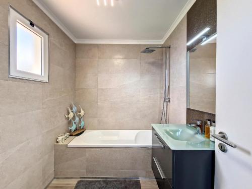 ein Badezimmer mit einer Badewanne und einem Waschbecken in der Unterkunft Villa Liana by LovelyStay in Ponta do Sol