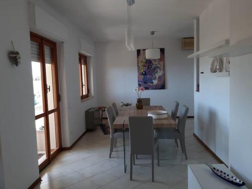 een keuken en eetkamer met een tafel en stoelen bij Villa Dormi'RE Sul Golfo in Su Forti