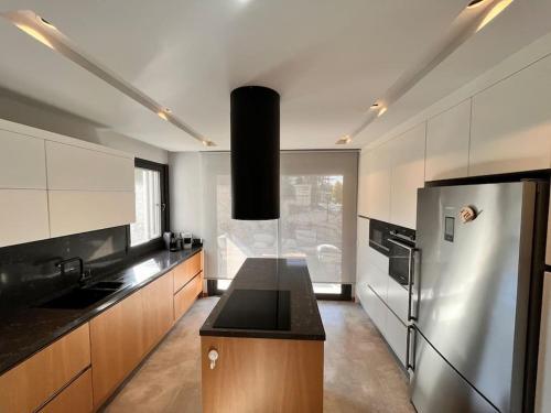a kitchen with a black counter top and a refrigerator at Sakin ve huzurlu bir tatil için… in Çeşme