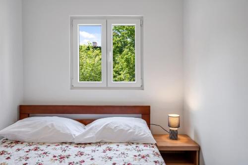 een slaapkamer met een bed en een raam bij Apartments Zlarin in Zlarin
