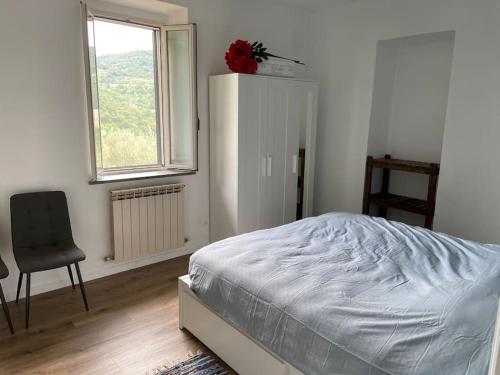 een slaapkamer met een bed, een stoel en een raam bij i Fiori in Cibottola
