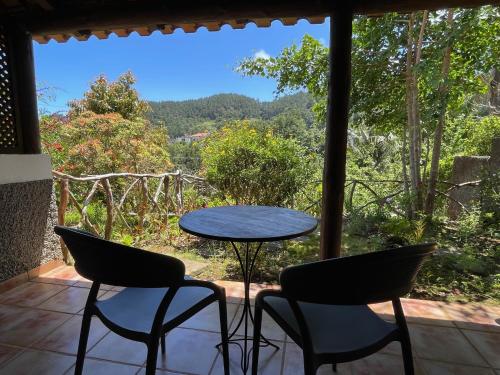 a table and chairs on a porch with a view at Casas de Campo do Pomar B&B - Self Check-in in Santana