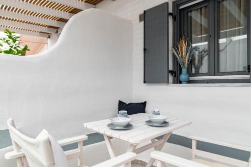 a white dining room with a white table and chairs at Lemon tree lipsi in Leipsoi