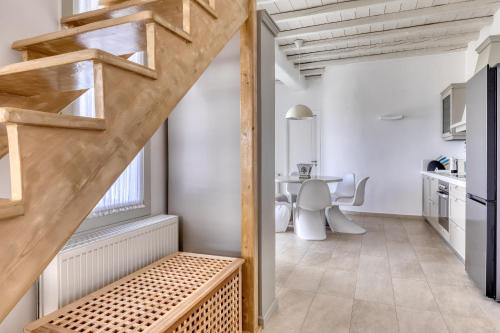 a room with a staircase and a kitchen with a table at Villa Ainar in Tinos Town