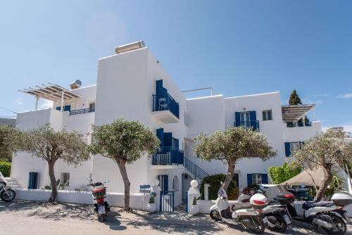 a white building with scooters parked in front of it at Livadia Seaside Studios 6 in Parikia