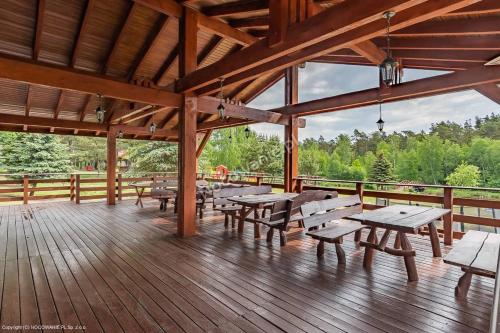 a pavilion with picnic tables and benches on a deck at Mimoza Gospodarstwo Agroturystyczne in Bartoszyce