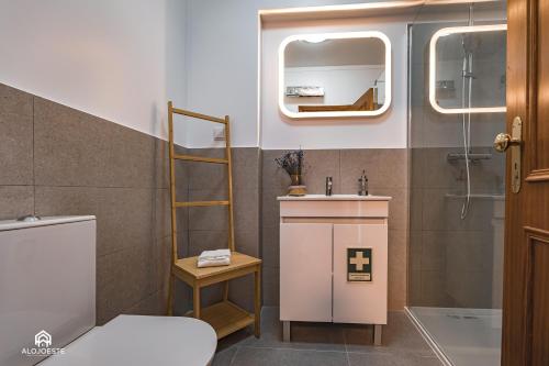 a bathroom with a toilet and a sink and a mirror at Ondas do Pisão Apartment - 2 bedroom and Sea View in Santa Cruz