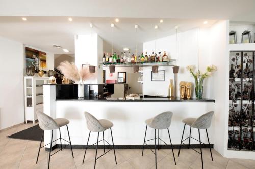 a kitchen with a bar with stools in front of it at Hotel El Salvador Frontemare Piscina Riscaldata in Lido di Jesolo