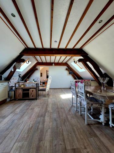 un grenier avec une table et des chaises dans une pièce dans l'établissement La Maison Au 1894 bulles de bonheur, à Avize
