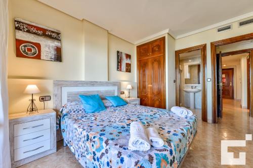 a bedroom with a large bed with blue pillows at Apartamento Realet 1F - Grupo Turis in Calpe