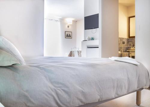 um quarto com uma cama grande e lençóis brancos em Camera Astrid em Casale Alxi