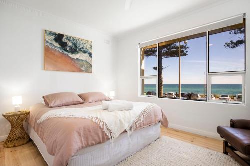 a bedroom with a bed and a view of the ocean at Luxury Beachfront Retreat on Henley Beach Esplanade in Henley Beach South