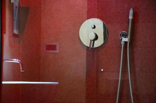 a shower in a bathroom with a red wall at Hotel Cimarosa in Naples
