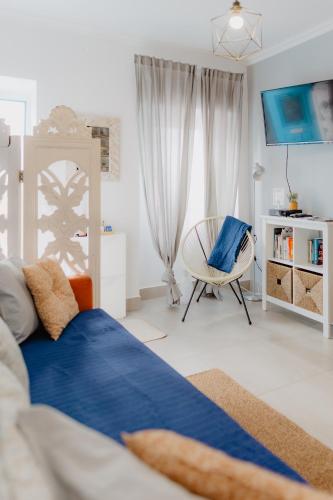 a bedroom with a blue bed and a chair at Home Santa Clara in Albufeira