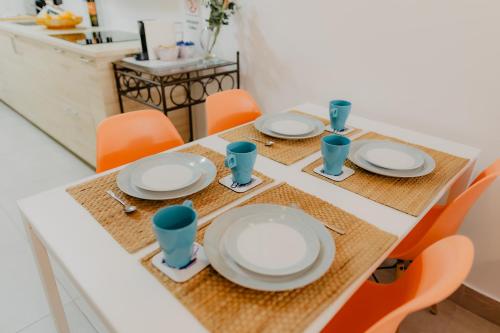 a table with white plates and blue cups on it at Home Santa Clara in Albufeira