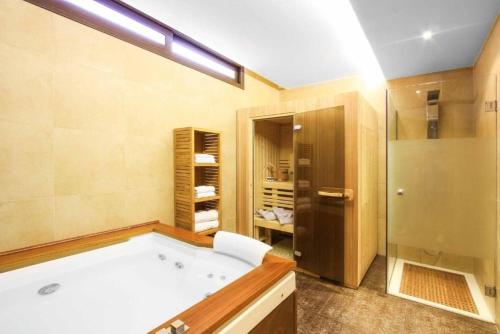 een grote badkamer met een bad en een douche bij Solis Lindos Villa in Lindos