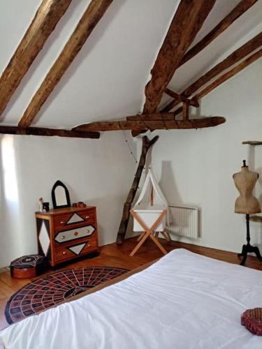 - une chambre avec un lit blanc et des poutres en bois dans l'établissement Grande maison cévenole à la décoration soignée, à Notre-Dame-de-la-Rouvière