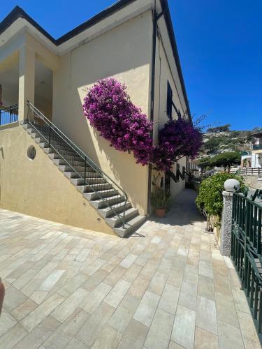 a house with purple flowers on the side of it at B&B L'albero di Melograno in Seccheto