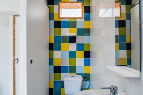 La salle de bains est pourvue de toilettes et d'un mur carrelé coloré. dans l'établissement Memories of Lisbon, à Lisbonne
