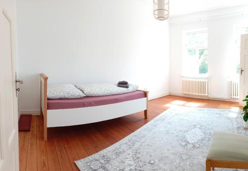 a bedroom with a bed and a rug at Norby Garden Westwärts in Rieseby
