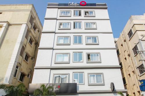 a tall white building with a sign on it at Townhouse Halcyon Hi-Tech City Near Medicover Hospital in Kondapur