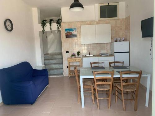 uma cozinha com mesa e cadeiras e um sofá azul em Casa Stella del Vesuvio em Portici