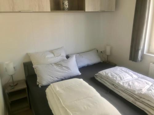 two beds in a room with white pillows at Mobilheim im Amazonas Camp - viel Platz und Komfort in Loitz