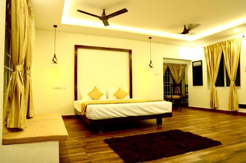 a bedroom with a bed and a ceiling fan at JACK'S DEN residency in Puducherry