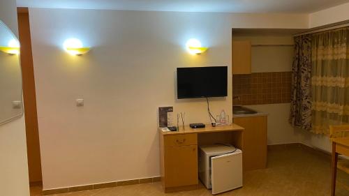 Habitación con escritorio y TV en la pared. en Esprit Hotel en Budapest