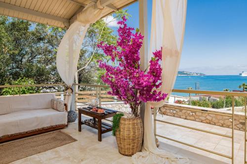 Orientem Villa في أرغاسي: غرفة معيشة مع أريكة وطاولة مع زهور