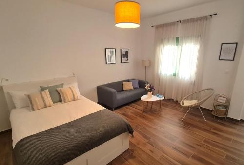 - une chambre avec un lit et un canapé dans l'établissement Yannis Guest House, à Égine