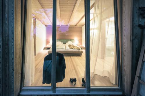 a glass window of a bedroom with a bed at Parkhotel Holzner in Soprabolzano