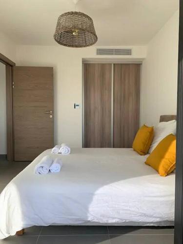 une chambre avec un grand lit blanc avec des serviettes dessus dans l'établissement Domaine d'Arca Eluard 02- PORTO-VECCHIO - Rez de jardin - 2 à 4 pers, à Porto-Vecchio