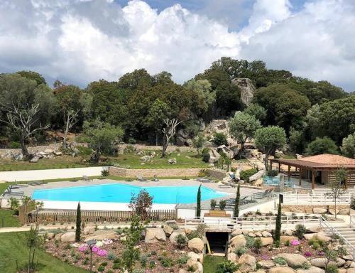 une grande piscine dans un parc arboré dans l'établissement Domaine d'Arca Eluard 02- PORTO-VECCHIO - Rez de jardin - 2 à 4 pers, à Porto-Vecchio