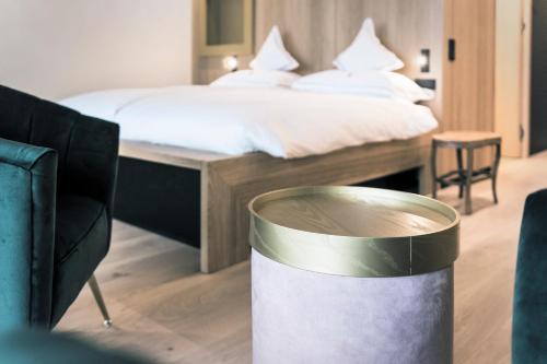 a hotel room with a bed and a trash can at Parkhotel Holzner in Soprabolzano