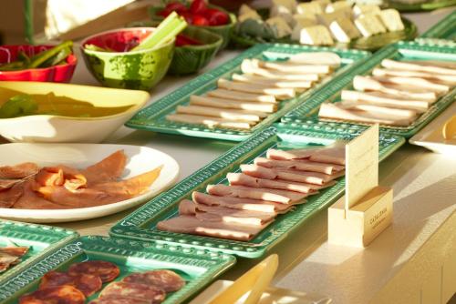a table with plates of meats and other foods at Catalonia Mirador des Port in Mahón