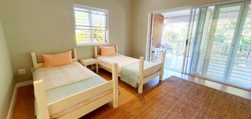 a small room with two beds and a balcony at Beach Haven - Sleeps 10 - Tastefully Furnished Holiday Home! in Margate