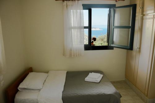 a bedroom with a bed and a window with a view at Perfetto Country House - Myrtos View in Anomeriá