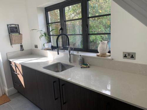 a kitchen with a sink and a window at LymingtonBnB in Lymington