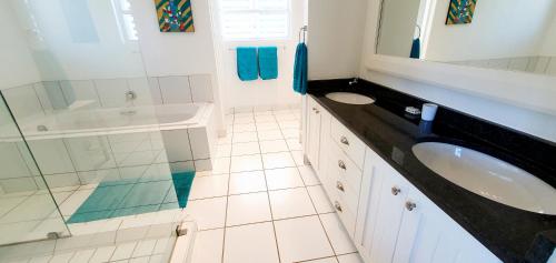 a bathroom with a sink and a tub and a mirror at Beach Haven - Sleeps 10 - Tastefully Furnished Holiday Home! in Margate