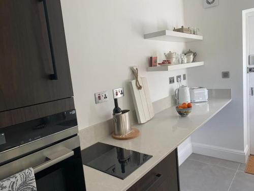 a kitchen with a counter with a sink and a stove at LymingtonBnB in Lymington