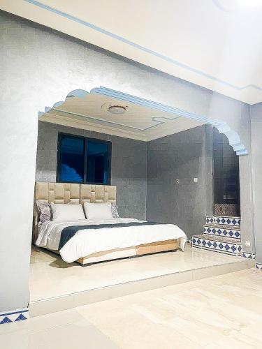Un dormitorio con una cama grande con un arco encima. en "Plaisir en Pleine Nature Villa Ferme avec Piscine Privée pour un Séjour Relaxant en Nzala