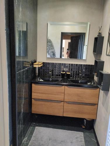 une salle de bain avec deux lavabos et un miroir dans l'établissement Au pied des vignes champenoise, à Cauroy-lès-Hermonville