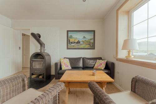 sala de estar con sofá y estufa de leña en Breathtaking View / 5-BR House / Scenic Village en Bøur