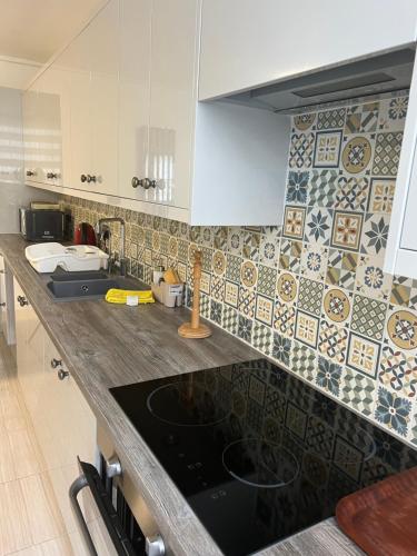 cocina con encimera con fregadero y azulejos en Private room 2 en Londres